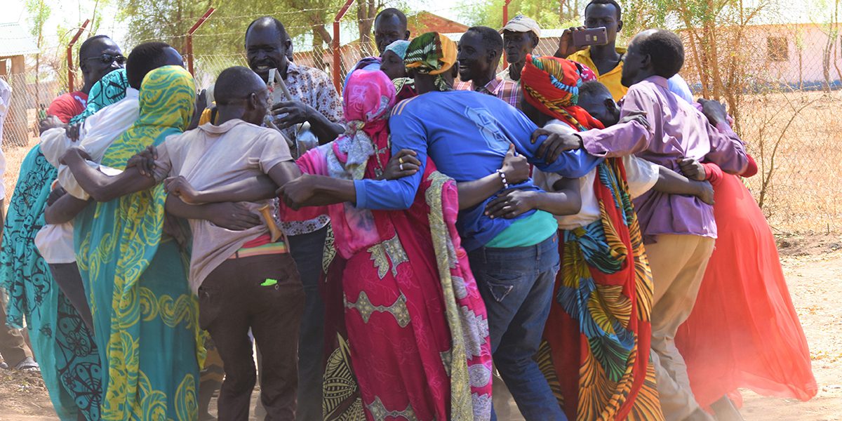 Un grupo de adultos baila, canta y forma un corro preparándose para la celebración del Día Internacional de la Mujer en Maban, Sudán del Sur.