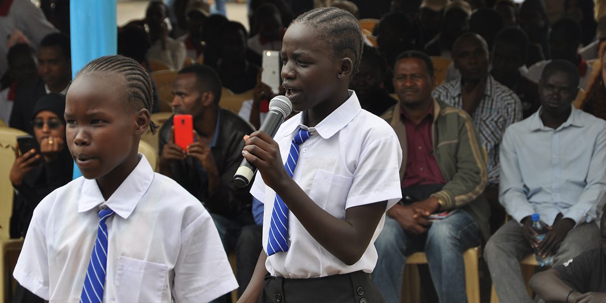 En el Día Mundial del Refugiado, una estudiante recita un poema en la escuela para refugiados.